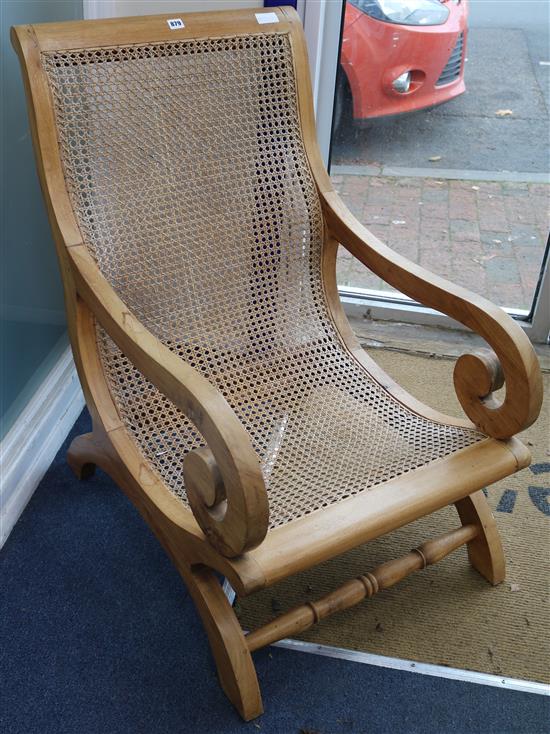 An Indian wood and rattan low armchair